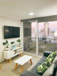 ein Wohnzimmer mit Couch und großem Fenster in der Unterkunft Bello departamento en el centro de Temuco in Temuco