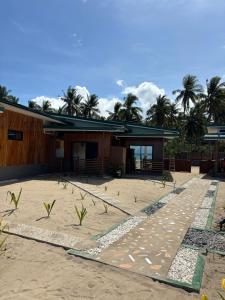 a building on the beach with palm trees in the background at Kattegat Beach Villas in El Nido