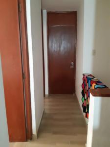 a hallway with a brown door and a wooden floor at Lily House in Ica +2 photos