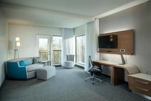 a hotel room with a bed and a desk with a tv at Courtyard by Marriott Corvallis in Corvallis
