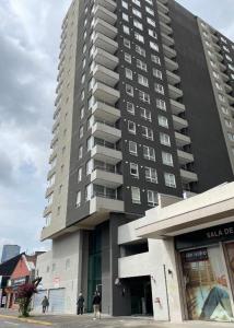 Ein hohes Gebäude mit Leuten, die davor laufen. in der Unterkunft Bello departamento en el centro de Temuco in Temuco