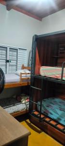 a room with bunk beds in a room with a table at Casa Roxa in Bonito