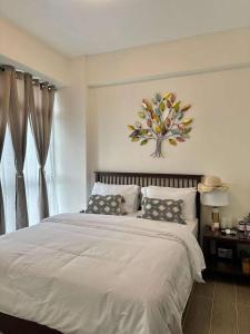 una camera da letto con un letto con un dipinto di fiori sul muro di Lily Nest De Boracay a Boracay