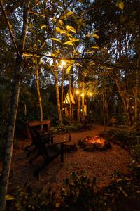 a park bench sitting next to a fire at night at Bosque Veneza in Nova Veneza