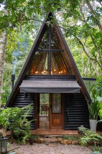 a tiny house with a triangular roof with a large window at Bosque Veneza in Nova Veneza +31 photos