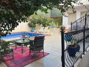 利雅德شاليه سافاير الرفيعة的游泳池旁边有一张桌子和椅子的露台