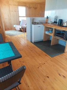 a kitchen with a wooden floor and a wooden table at Refugio del Archipielago D3 in Punta de Choros
