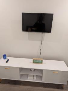 a white desk with a tv on a white wall at Joonam Luxury Room For You In Peachtree Corners with Private Bath in Peachtree Corners