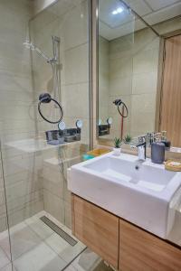 une salle de bain avec un lavabo blanc et une douche dans l'établissement Stylish Studio Retreat, à Dubaï