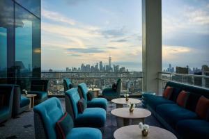 a room with chairs and tables and a view of a city at The Ritz-Carlton New York, NoMad in New York