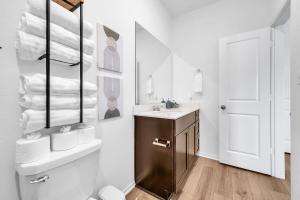 a bathroom with a sink and a toilet and a mirror at Austin Hideaway - King Bed, Game Room, FREE Coffee in Pflugerville