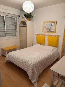 a bedroom with a large bed with yellow pillows at Maison les dunes proche plage in Quiberon +43 photos
