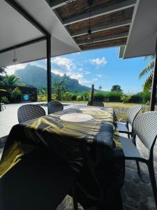 a patio with a table and chairs with a view at Fare Moorea in Moorea +5 photos