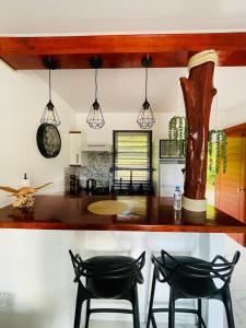 a kitchen with two black chairs and a counter at Fare Moorea in Moorea