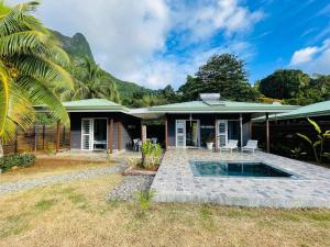 a house with a pool in front of it at Fare Moorea in Moorea