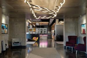 a lobby with chairs and tables and a chandelier at Aloft Sarasota in Sarasota