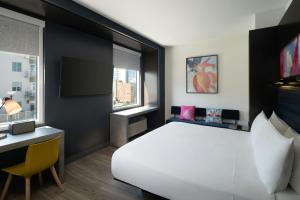 a bedroom with a large white bed and a desk at Aloft Sarasota in Sarasota