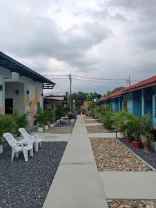 a walkway with white chairs and a row of houses at SK Hometel Samui Airport in Bang Rak Beach