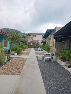 a long walkway between two buildings with benches at SK Hometel Samui Airport in Bang Rak Beach +37 photos