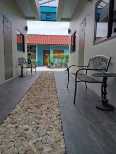a patio with two chairs and a stone floor at SK Hometel Samui Airport in Bang Rak Beach