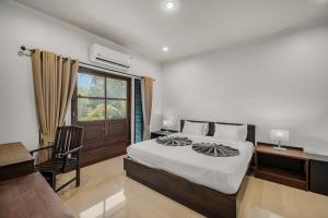 a bedroom with a bed and a desk and a window at SimPly Stay Fisherman's Village in Amphoe Koh Samui