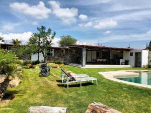 Un patio trasero con piscina y una casa. en Villas ARVEM 2 enjoy nature, en Atlixco