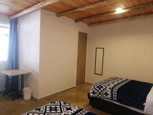 Un dormitorio con dos camas y una mesa y una ventana. en Villas ARVEM 2 enjoy nature, en Atlixco