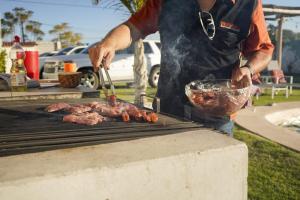 un hombre está cocinando carne en una parrilla en Villas ARVEM 2 enjoy nature, en Atlixco