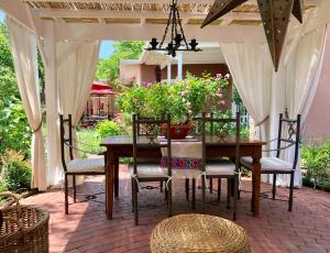 a patio with a wooden table with chairs and flowers at Casa Culinaria - The Gourmet Inn in Santa Fe