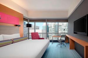 a hotel room with a bed and a desk and a television at Aloft Kuala Lumpur Sentral in Kuala Lumpur