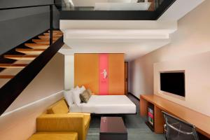 a living room with a couch and a staircase at Aloft Kuala Lumpur Sentral in Kuala Lumpur