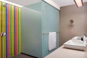 a bathroom with a sink and a glass shower at Aloft Kuala Lumpur Sentral in Kuala Lumpur