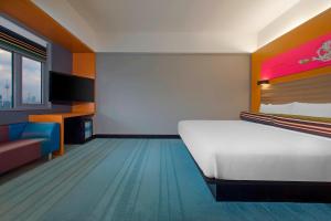 a large room with a bed and a tv at Aloft Kuala Lumpur Sentral in Kuala Lumpur