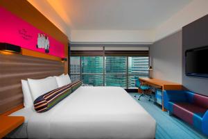 a hotel room with a bed and a desk and a tv at Aloft Kuala Lumpur Sentral in Kuala Lumpur