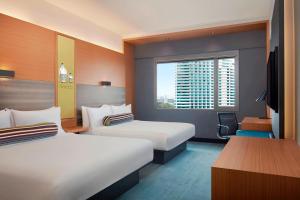 a hotel room with two beds and a window at Aloft Kuala Lumpur Sentral in Kuala Lumpur