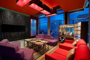 a living room with red furniture and a large window at Aloft Kuala Lumpur Sentral in Kuala Lumpur