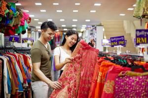 a man and woman looking at a sari in a store at Aloft Kuala Lumpur Sentral in Kuala Lumpur