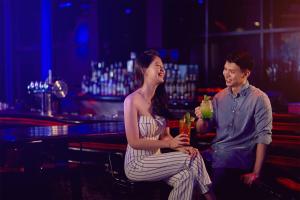 a man and a woman sitting in a bar with drinks at Aloft Kuala Lumpur Sentral in Kuala Lumpur
