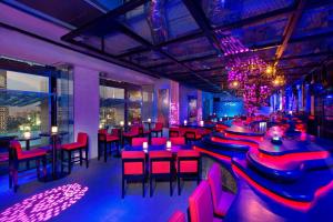 a restaurant with red chairs and tables and a chandelier at Aloft Kuala Lumpur Sentral in Kuala Lumpur +37 photos