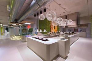 a restaurant with chandeliers and counters in a room at Aloft Kuala Lumpur Sentral in Kuala Lumpur