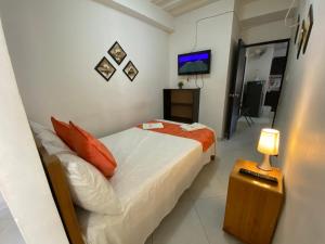 a bedroom with a bed and a television in it at Casa Linda in Santa Marta