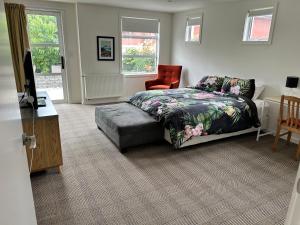 a bedroom with a bed and a desk and a chair at Cbay 2 bedroom Suite in Timaru