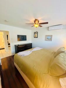 ein Schlafzimmer mit einem Bett und einem Deckenventilator in der Unterkunft 2 min walk to beach & free parking Lauderdale 21-2 in Fort Lauderdale