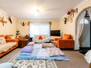 un soggiorno con 2 divani e un divano di BIDWILL GARDENS ON MIDDLETON - Private Room King-Size Bed or Open Lounge Room Floor Mattress SHARED Bathroom FREE Kitchen Essentials FREE Laundry Facilities Fast NBN WIFI HDTV NETFLIX, YOUTUBE, KAYO Private Transport and Meal Services Available On Request a Bidwill