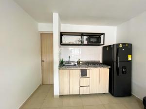 Una cocina con un refrigerador negro y un fregadero. en loft dreams 7006, en Medellín