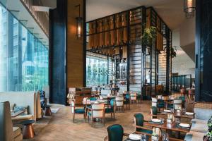 restauracja ze stołami, krzesłami i oknami w obiekcie Renaissance Hong Kong Harbour View Hotel w Hongkongu
