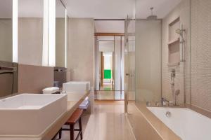 bagno con 2 lavandini, vasca e doccia di Courtyard by Marriott Hong Kong Sha Tin a Hong Kong