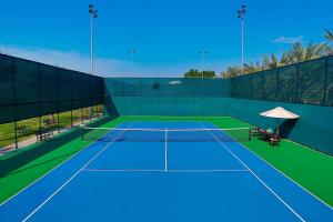 a tennis court with a tennis net on it at Al Habtoor Grand Resort, Autograph Collection in Dubai +37 photos