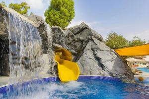 a water slide in a pool with a waterfall at Al Habtoor Grand Resort, Autograph Collection in Dubai