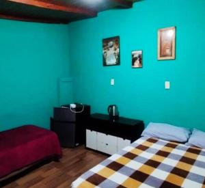 a bedroom with blue walls and a bed and a desk at Cápsula 127 in Puerto Iguazú +69 photos